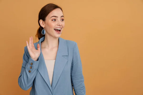 Jonge Gember Vrouw Jas Lachen Zwaaien Hand Geïsoleerd Gele Achtergrond — Stockfoto