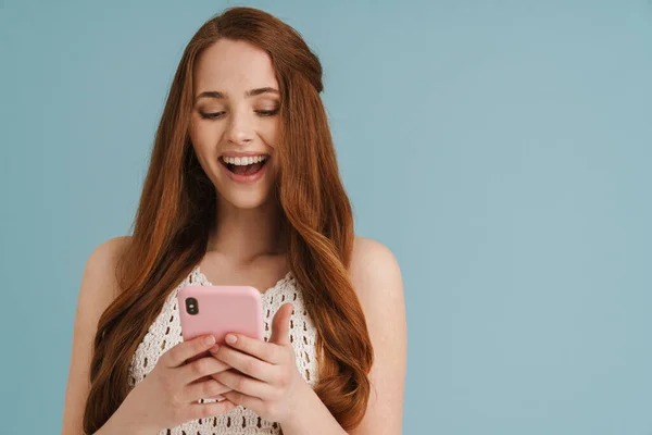 Молодая Рыжая Женщина Смеется Используя Мобильный Телефон Синем Фоне — стоковое фото