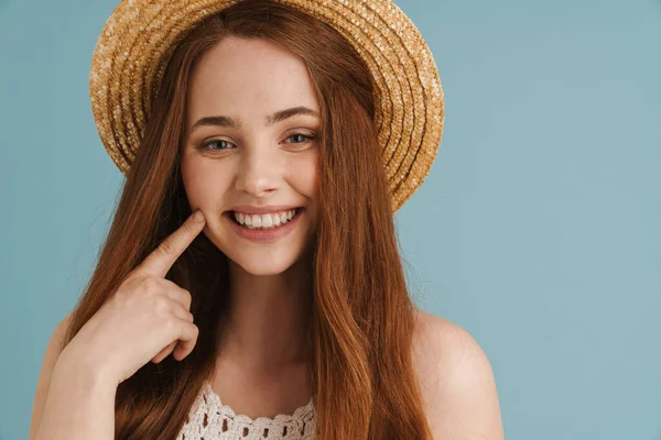 Νεαρή Κοκκινομάλλα Ψάθινο Καπέλο Χαμογελώντας Και Δείχνοντας Μάγουλό Της Απομονωμένη — Φωτογραφία Αρχείου