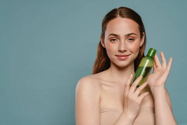 Mujer Pelirroja Semidesnuda Sonriendo Mostrando Loción Facial Aislada Sobre Fondo —  Fotos de Stock