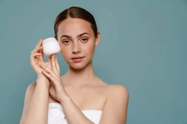 Joven Mujer Pelo Castaño Sonriente Mostrando Tarro Crema Pie Sobre —  Fotos de Stock