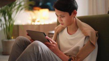 Düşünceli Asyalı adam tablete bakıyor ve gidiyor.