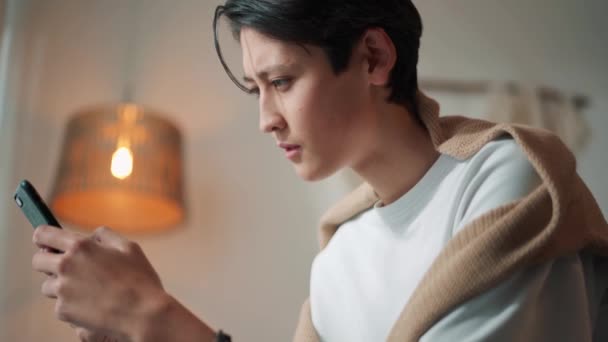 Serious Asiático Hombre Mensajes Texto Por Teléfono Casa — Vídeos de Stock