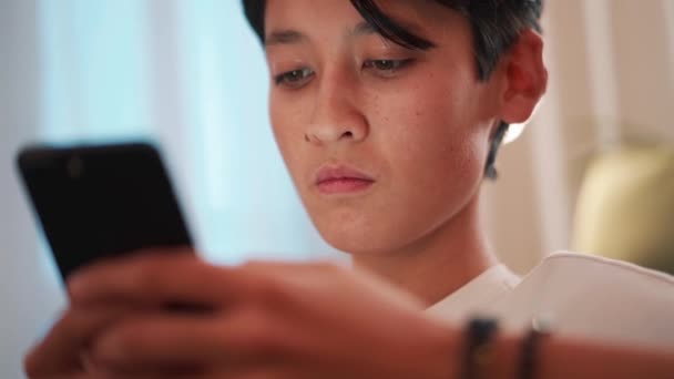 Schön Brünett Asiatisch Mann Texting Telefon Auf Die Sofa — Stockvideo