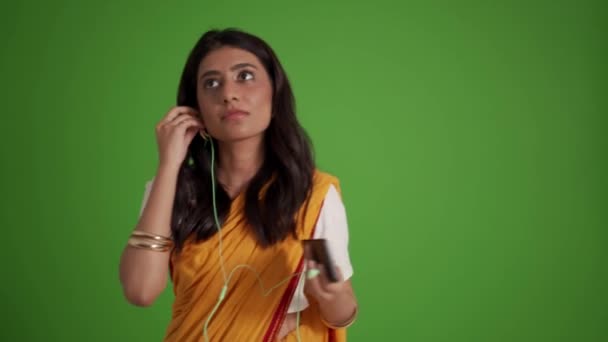 Positieve Traditionele Indiase Vrouw Luisteren Muziek Hoofdtelefoon Dansen Groene Studio — Stockvideo