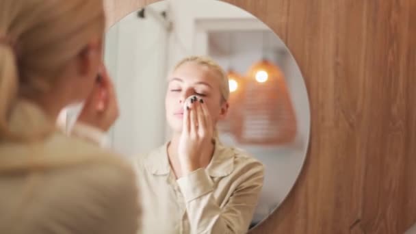 Concentrated Blond Woman Wiping Her Face Sponge Mirror Home — Stock Video