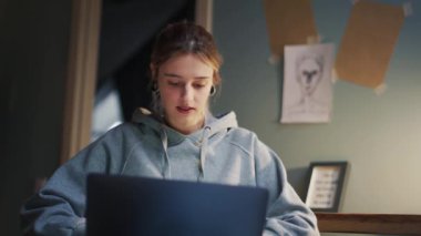 Evde dizüstü bilgisayarla yazan olumlu kadın.