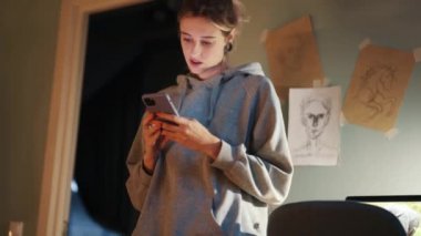 Evdeki odada telefonla mesaj atan düşünceli bir kadın.