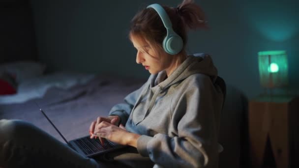 Poważna Kobieta Słuchawkach Wpisując Laptopa Domu — Wideo stockowe