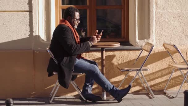 Concentrato Uomo Africano Occhiali Foglia Nastro Telefono Caffè All Aperto — Video Stock