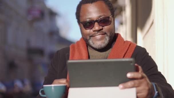 Hombre Africano Positivo Anteojos Hablando Por Videollamada Tableta Beber Café — Vídeos de Stock