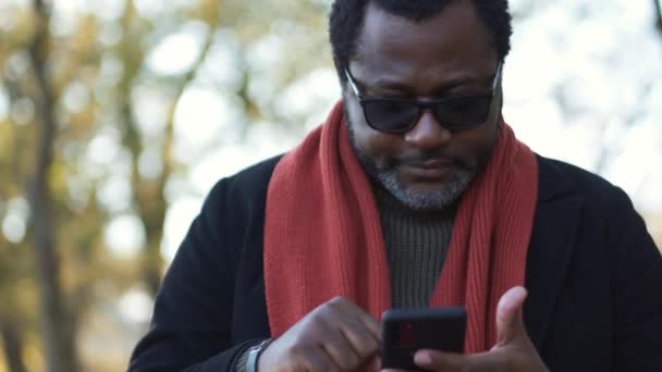 Självsäker Afrikansk Man Skriva Med Telefon Parken Utomhus — Stockvideo