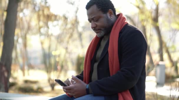 Seriózní Africký Muž Listování Pásku Telefonu Parku Venku — Stock video