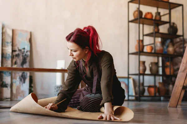 Young Woman Artist Sitting Floor Art Studio Unrolling Parchment Paper — Stock Photo, Image