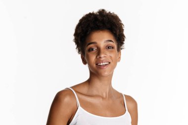 Young black woman in tank top smiling and looking at camera isolated over white background