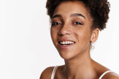 Young black woman in tank top smiling and looking at camera isolated over white background