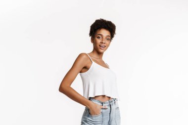 Young black woman in tank top smiling and looking at camera isolated over white background