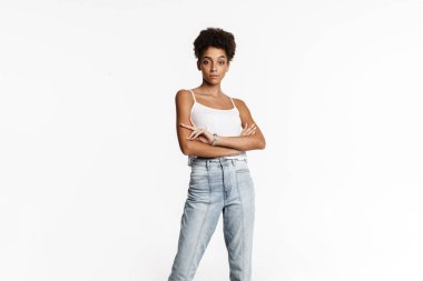 Young black woman in tank top posing and looking at camera isolated over white background