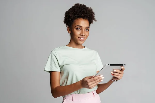 Young Black Woman Smiling While Using Tablet Computer Isolated Grey — стоковое фото