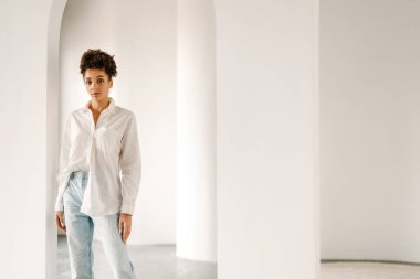 Young black woman standing and looking at camera indoors