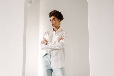Young black woman standing and looking aside indoors