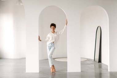 Young black woman standing and looking at camera indoors
