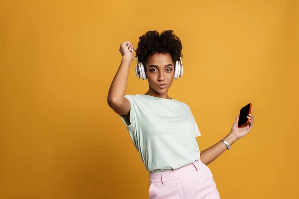 Young Black Woman Listening Music Headphones Dancing Isolated Yellow Background — Stockfoto