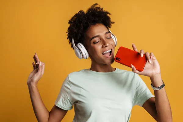 Young Black Woman Listening Music Headphones Singing Isolated Yellow Background — Stockfoto