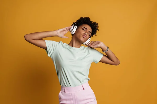 Young Black Woman Listening Music Headphones Grimacing Isolated Yellow Background — Stockfoto