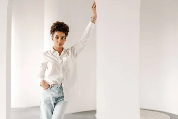 Young Black Woman Leaning Wall Looking Camera Indoors — Stockfoto