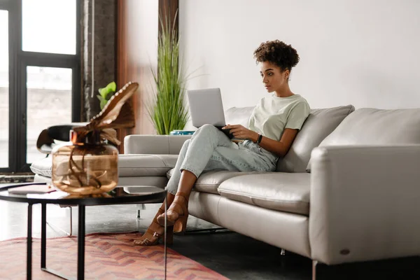 Young Black Woman Working Laptop While Sitting Couch Home — Stockfoto