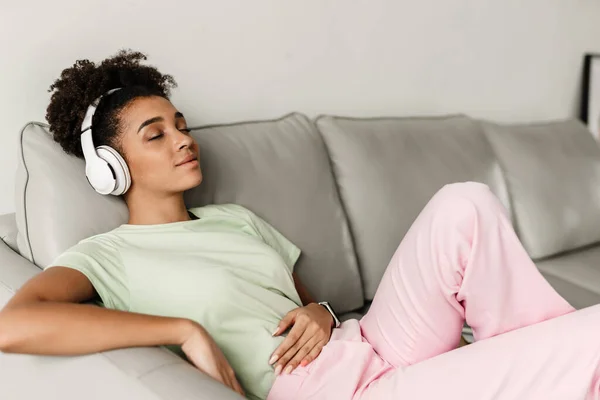Young Black Woman Listening Music Headphones While Sitting Couch Home — Foto Stock