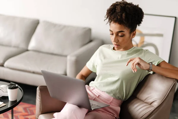 Young Black Woman Working Laptop While Sitting Armchair Home — 图库照片