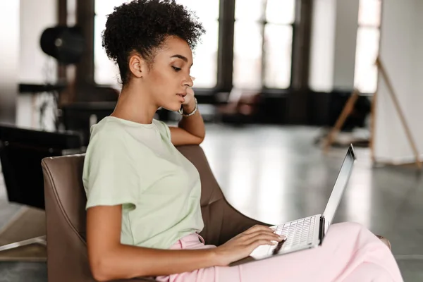 Young Black Woman Working Laptop While Sitting Armchair Home — Stockfoto