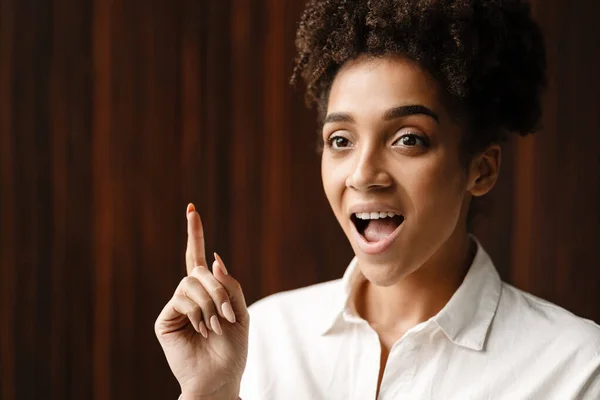 Young Black Woman Expressing Surprise Pointing Finger Upward Indoors — Foto Stock