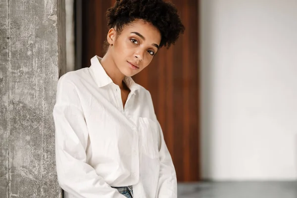 Young Black Woman Leaning Wall Looking Camera Indoors — Stockfoto