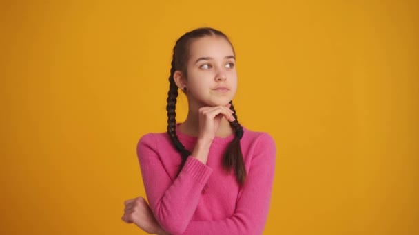 Chica Pensativa Con Coletas Mirando Alrededor Estudio Amarillo — Vídeo de stock