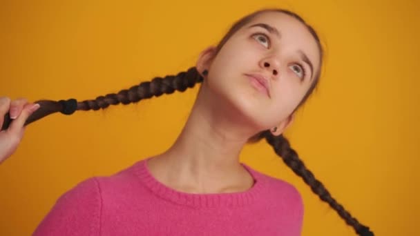 Chica Feliz Con Coletas Mostrando Lengua Cámara Estudio Amarillo — Vídeo de stock