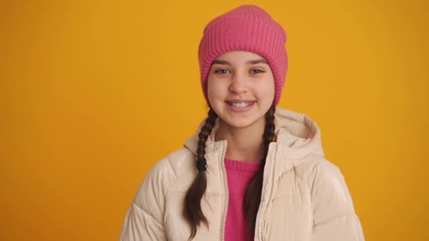 Χαρούμενο Κορίτσι Κοτσίδες Φυσάει Αερόφιλο Στην Κάμερα Στο Κίτρινο Στούντιο — Αρχείο Βίντεο