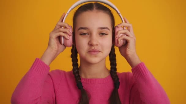 Smiling Girl Pigtails Wearing Headphones Yellow Studio — Vídeos de Stock