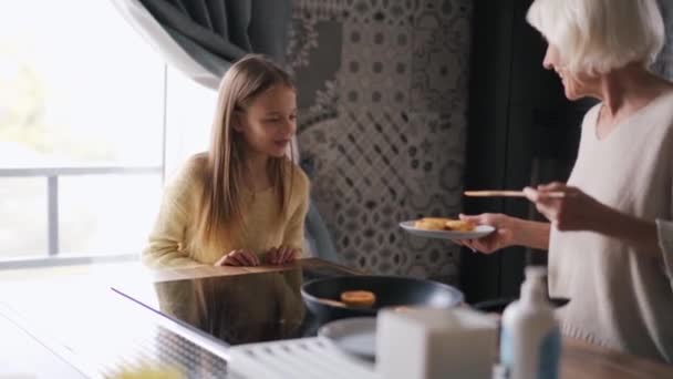 Positive Grandmother Gives Cooked Cheesecakes Her Granddaughter Kitchen — Stock video