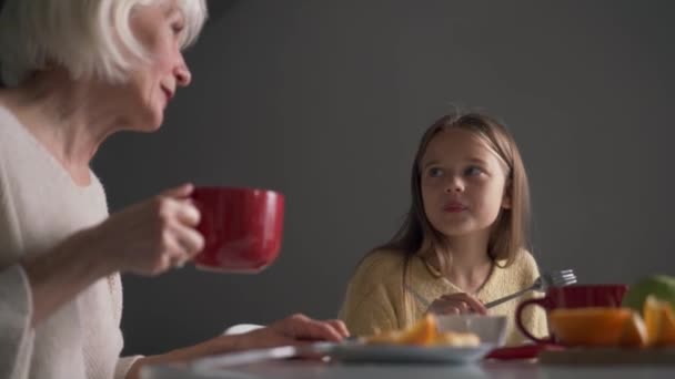 Happy Grandmother Granddaughter Eating Breakfast Talking Kitchen — Video Stock