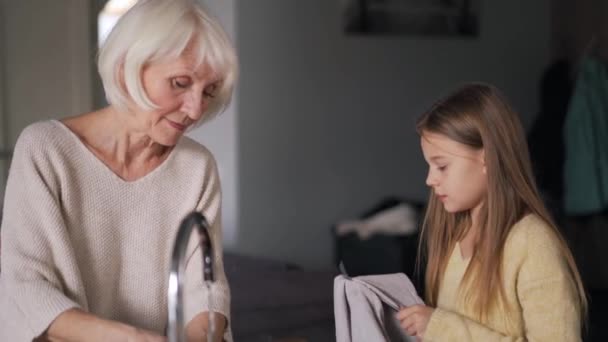 Positive Girl Helps Wash Dishes Her Grandmother Kitchen Home — Stockvideo