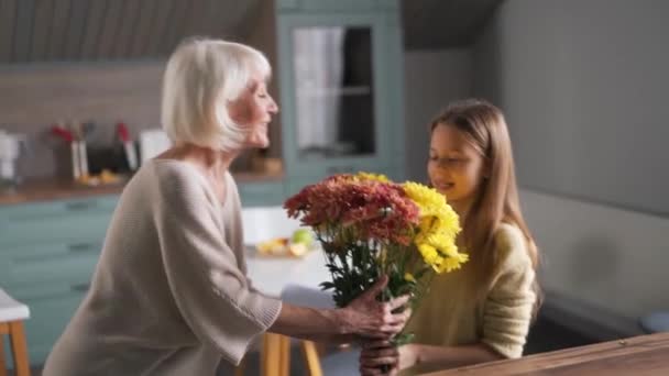 Evde Elinde Bir Buket Çiçek Tutan Büyükannesiyle Pozitif Bir Kız — Stok video