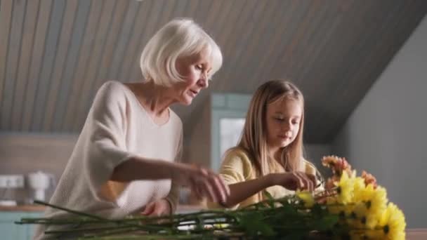 Concentrated Girl Helps Her Grandmother Collect Bouquet Flowers Home — Vídeo de Stock