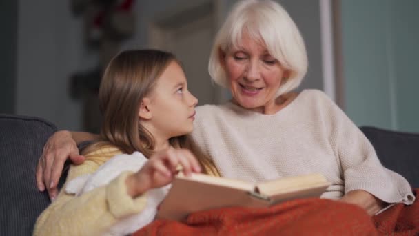 Concentrated Girl Her Grandmother Reading Book Sofa Home — Vídeo de Stock