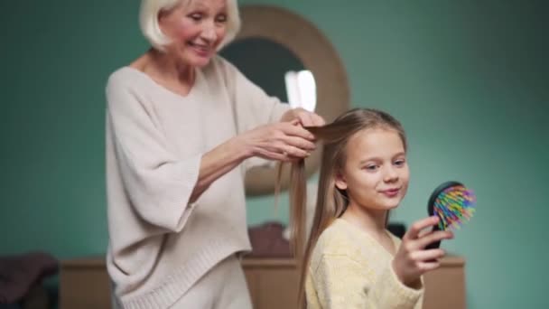 Happy Grandmother Braiding Her Granddaughter Hair Home — Vídeo de Stock