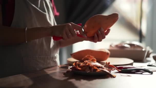 Γυναικεία Χέρια Ξεφλουδίζουν Γλυκοπατάτες Στην Κουζίνα — Αρχείο Βίντεο