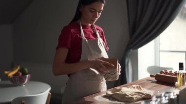 Mutfağa un serpiştiren ciddi bir kadın.