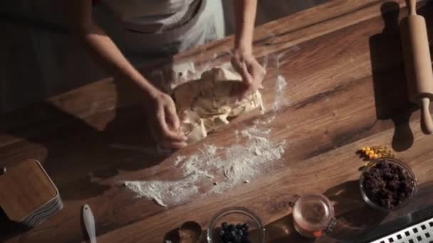 台所でテーブルの上に生地をこねる女性のオーバーヘッドビュー — ストック動画